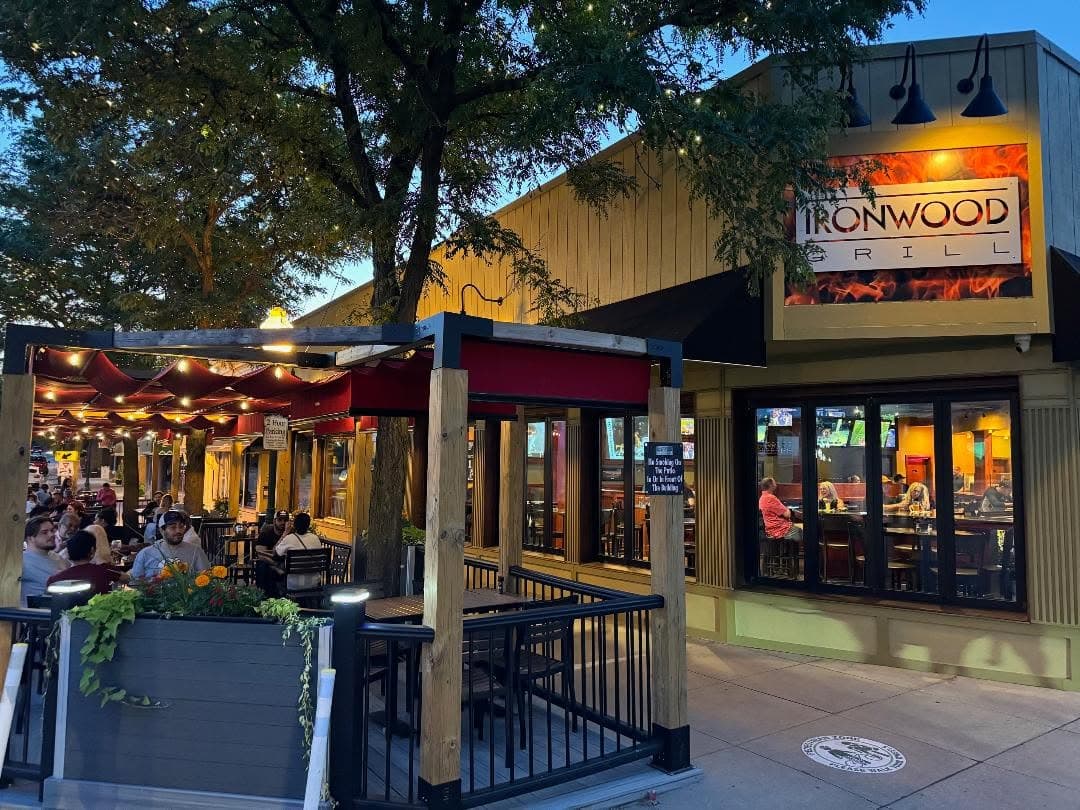 The Ironwood Grill patio at dusk, strung with warm lights