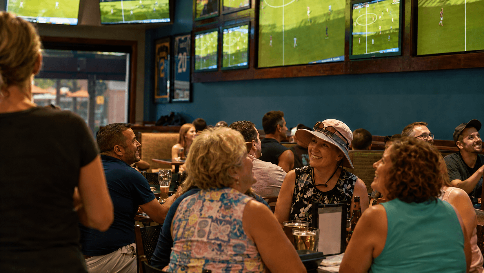 Guests watching the sports game on the TVs