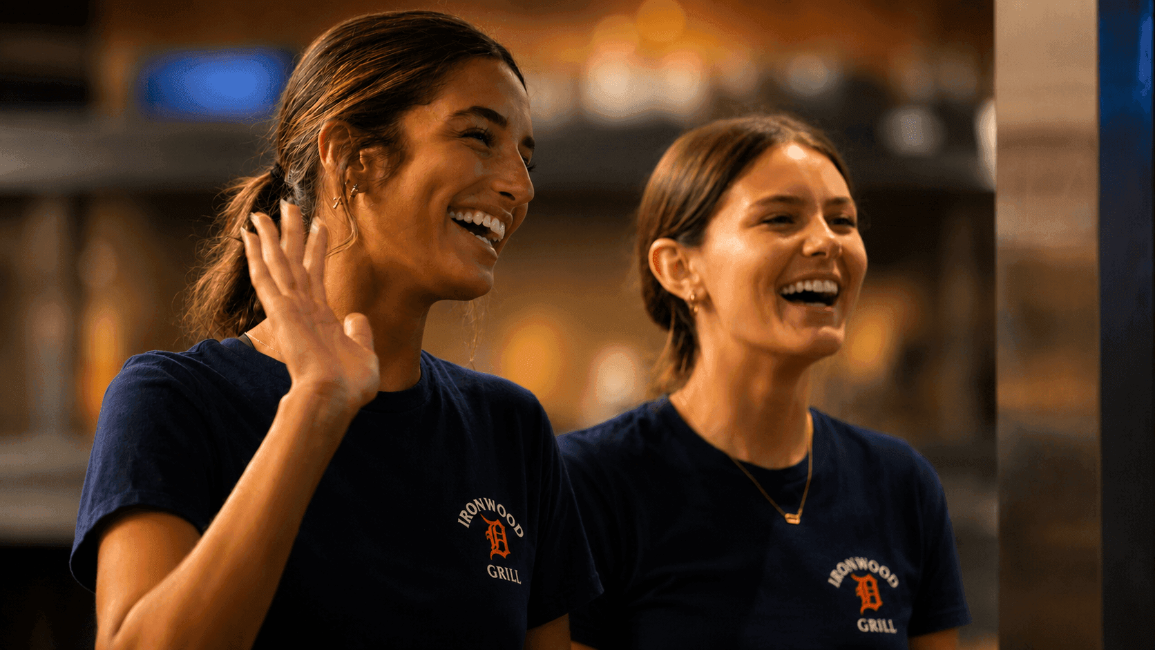 Two waitresses smiling and waving