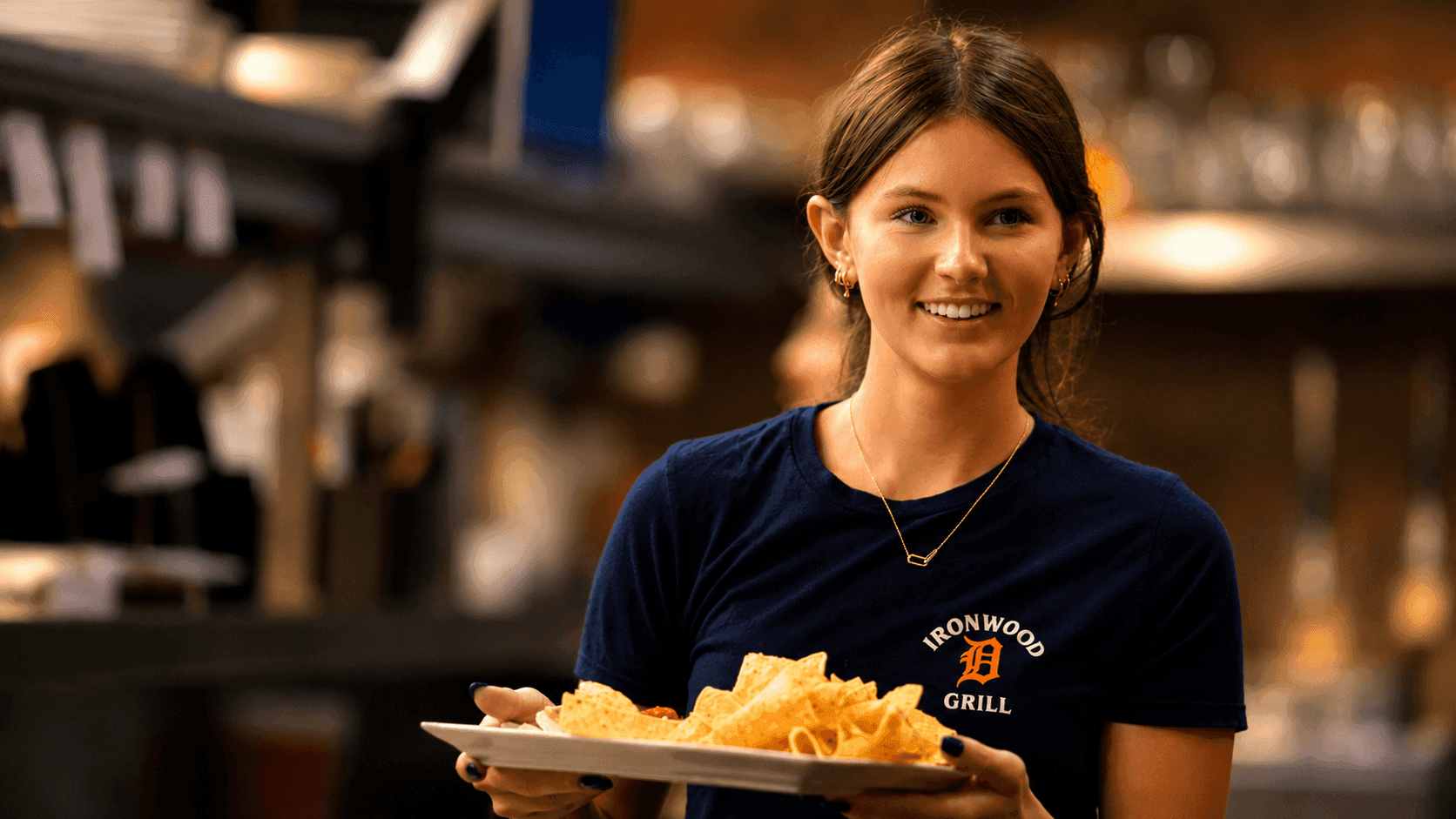 A waitress carrying a plate of chips
